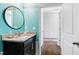 Stylish bathroom with a granite countertop, dark vanity, and a round mirror at 7525 Poplar Meadow Ln, Raleigh, NC 27616