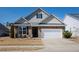 Charming two-story home featuring a stone facade, a two-car garage, and a well-maintained front yard at 7525 Poplar Meadow Ln, Raleigh, NC 27616