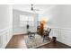 Bright living room featuring hardwood floors, a ceiling fan, and traditional wainscoting at 7525 Poplar Meadow Ln, Raleigh, NC 27616