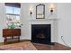 Charming living area featuring a fireplace with decorative mantle, hardwood flooring, and abundant natural light at 7525 Poplar Meadow Ln, Raleigh, NC 27616