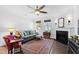 Cozy living room featuring a fireplace, hardwood floors, a ceiling fan, and natural light at 7525 Poplar Meadow Ln, Raleigh, NC 27616