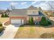 Aerial view of the home with a large yard, brick exterior, and a two-car garage at 7800 Twin Pines Way, Fuquay Varina, NC 27526
