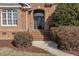 Close-up of a brick home's decorative front door, complemented by lush landscaping and arched windows at 7800 Twin Pines Way, Fuquay Varina, NC 27526