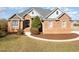Charming brick home featuring a landscaped front yard, arched entryway, and multiple windows at 7800 Twin Pines Way, Fuquay Varina, NC 27526