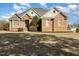 Charming brick home with a manicured front lawn and symmetrical design under a partly cloudy sky at 7800 Twin Pines Way, Fuquay Varina, NC 27526