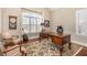 Bright home office with a large window, hardwood floors, and a classic wooden desk at 7800 Twin Pines Way, Fuquay Varina, NC 27526