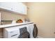 Practical laundry room with white appliances, cabinets and countertop at 7800 Twin Pines Way, Fuquay Varina, NC 27526