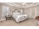 Serene main bedroom with a decorative tray ceiling and access to the ensuite bathroom at 7800 Twin Pines Way, Fuquay Varina, NC 27526
