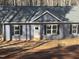 Newly constructed home showcasing light blue siding, black shutters, and a grey roof at 810 Jasmine Rd, Fuquay Varina, NC 27526