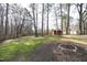 Expansive backyard featuring a fire pit and a storage shed surrounded by mature trees at 8125 Middleton Rd, Garner, NC 27529