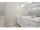 Bathroom featuring a double sink vanity with white cabinets and a large mirror reflecting the tiled shower at 816 Still Willow Ln, Wendell, NC 27591