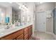 Bright bathroom featuring a double sink vanity, a large mirror, and neutral decor at 82 Wood Valley Dr, Four Oaks, NC 27524