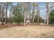 Expansive backyard with mature trees, a storage shed, and a white picket fence at 8513 Barrett Hall Ln, Wake Forest, NC 27587