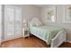 Comfortable bedroom with a single bed, hardwood floors, and light-filled windows at 8513 Barrett Hall Ln, Wake Forest, NC 27587
