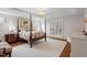 Spacious bedroom featuring a four-poster bed, tray ceiling, hardwood floors, and shuttered windows at 8513 Barrett Hall Ln, Wake Forest, NC 27587