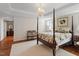 Cozy main bedroom featuring a four-poster bed, neutral walls, hardwood floors and simple furnishings at 8513 Barrett Hall Ln, Wake Forest, NC 27587