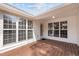A cozy back porch with a wooden floor, lots of natural light, and a door to the house at 100 W Acres Cres, Cary, NC 27519