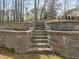 Backyard with stone walls and stairs leading to an upper level, perfect for landscaping or creating a garden at 100 W Acres Cres, Cary, NC 27519