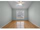 Bright bedroom features hardwood floors, a ceiling fan, and a large window at 100 W Acres Cres, Cary, NC 27519