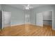 A bedroom with hardwood floors, a ceiling fan, and access to the bathroom and closet at 100 W Acres Cres, Cary, NC 27519