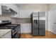 Kitchen featuring modern appliances, white cabinets, and wood flooring at 100 W Acres Cres, Cary, NC 27519