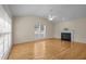 Bright living room features hardwood floors, a fireplace, and a large window at 100 W Acres Cres, Cary, NC 27519