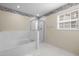 A main bathroom with a separate shower, soaking tub, white tile, and a window at 100 W Acres Cres, Cary, NC 27519