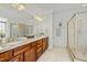 Bathroom featuring a double sink vanity with wood cabinets and a glass shower at 10040 Ward, Chapel Hill, NC 27517