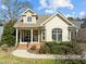 Inviting home exterior showcasing a covered porch and brick accents under bright skies at 10040 Ward, Chapel Hill, NC 27517