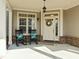 Welcoming front porch featuring rocking chairs, decorative pillows, and a charming wreath on the door at 10040 Ward, Chapel Hill, NC 27517