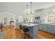 Spacious kitchen featuring an island with barstool seating, pendant lighting, and hardwood floors at 10040 Ward, Chapel Hill, NC 27517