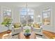 Bright sitting room with comfortable chairs, a round wood table, and arched windows at 10040 Ward, Chapel Hill, NC 27517