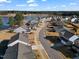 Aerial view of a neighborhood with single-Gathering homes located on a waterfront property surrounded by lush trees at 1008 Sandtrap Way, Durham, NC 27703