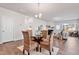 Bright dining area with a glass-top table, wicker chairs, and an open layout into the living room at 1008 Sandtrap Way, Durham, NC 27703