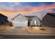 Charming single-story home with gray siding, a two-car garage, and a well-manicured front lawn at dusk at 1008 Sandtrap Way, Durham, NC 27703