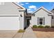 Inviting entrance with a well-lit walkway, manicured landscaping, and a charming wreath on the front door at 1008 Sandtrap Way, Durham, NC 27703