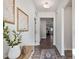 Bright hallway featuring stylish decor, wood floors, and a view into the living room at 1008 Sandtrap Way, Durham, NC 27703