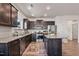 Modern kitchen with dark cabinets, granite countertops, stainless steel appliances, and a functional island at 1008 Sandtrap Way, Durham, NC 27703