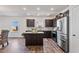 Contemporary kitchen featuring a center island, stainless steel refrigerator, and dark wood cabinetry at 1008 Sandtrap Way, Durham, NC 27703