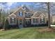 Beautiful two-story home with brick and stone exterior, well-manicured lawn and mature landscaping at 106 Rolling Meadows Ln, Chapel Hill, NC 27517