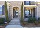 Charming covered front porch with stone archway, rocking chairs, and manicured landscaping at 106 Rolling Meadows Ln, Chapel Hill, NC 27517