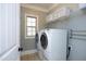 Bright laundry room features a window, washer, dryer, and convenient shelving at 106 Rolling Meadows Ln, Chapel Hill, NC 27517