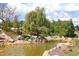 Tranquil pond surrounded by rocks, landscaping, and a weeping willow tree at 106 Rolling Meadows Ln, Chapel Hill, NC 27517