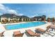 Beautiful community pool featuring lounge chairs, umbrellas, and adjacent clubhouse at 106 Rolling Meadows Ln, Chapel Hill, NC 27517
