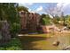 Scenic waterfall cascading into a pond, surrounded by lush greenery and rocks at 106 Rolling Meadows Ln, Chapel Hill, NC 27517