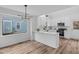 Modern white kitchen featuring stainless steel appliances, quartz countertops, and stylish lighting fixture at 107 Kingsmill Rd, Cary, NC 27511