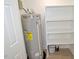 Utility room with a modern water heater, white storage shelves, and ample space at 108 Torain St, Hillsborough, NC 27278