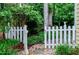 Backyard area with a small white picket fence, gravel, and greenery surrounding the space at 109 Reton Ct, Cary, NC 27513