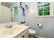 Bathroom with powder blue walls, decorative iron sconces, and a large window over toilet at 109 Reton Ct, Cary, NC 27513