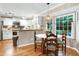Dining area featuring a bay window, hardwood floors, and white kitchen cabinets at 109 Reton Ct, Cary, NC 27513